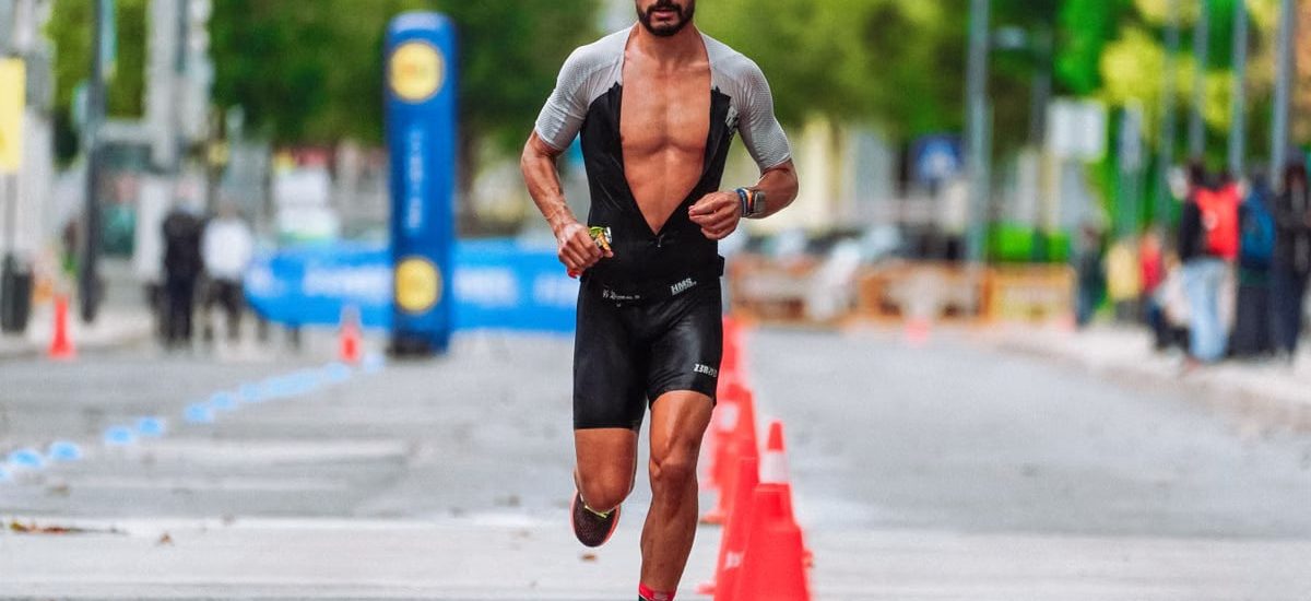 Focused male athlete running a marathon in an urban setting, showcasing endurance and determination.