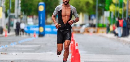Focused male athlete running a marathon in an urban setting, showcasing endurance and determination.