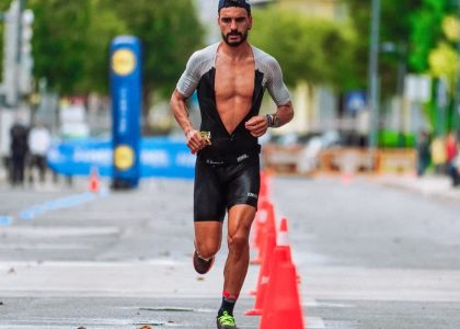 Focused male athlete running a marathon in an urban setting, showcasing endurance and determination.